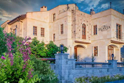 Flavia Cappadocia Hotel في أوشيسار: مبنى حجري كبير عليه لافته