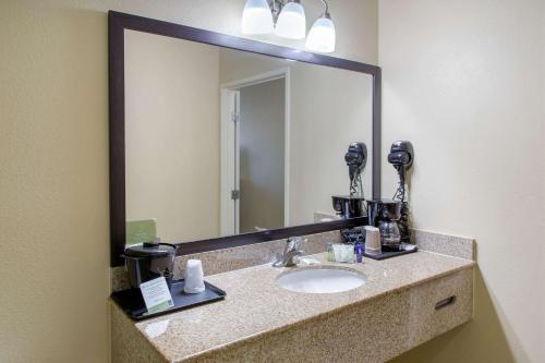 Sleep Inn & Suites Bakersfield North في بيكرسفيلد: حمام مع حوض ومرآة كبيرة