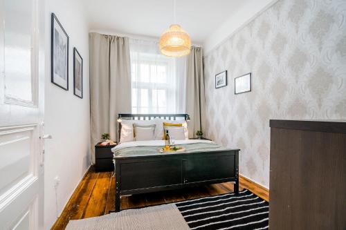 um quarto com uma cama e um lustre em Spacious APT in Prague Center by Michal&Friends em Praga