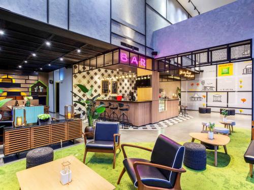 ibis Styles Bekasi Jatibening في بيكاسي: مطعم فيه طاولات وكراسي في الغرفة