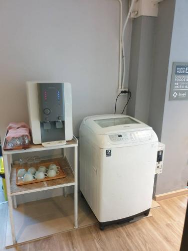 a washing machine sitting next to a small refrigerator at Nest by Sangob in Bangkok