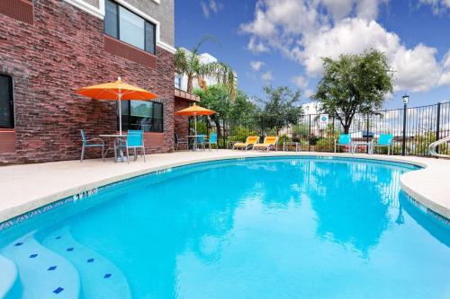 a swimming pool with chairs and an umbrella at Sleep Inn & Suites Tempe ASU Campus in Tempe