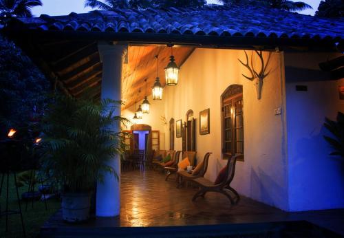 a porch of a house at night with chairs at Athulya Villas, Kandy in Kadugannawa