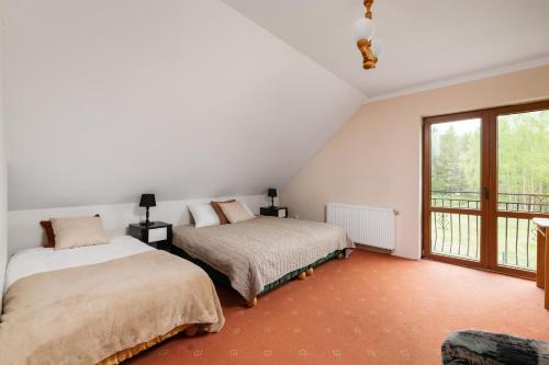 1 Schlafzimmer mit 2 Betten und einem Balkon in der Unterkunft Dom w Wolnicy - Wszystko do pełnego wypoczynku! 