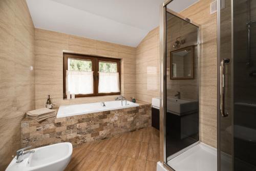 ein Badezimmer mit einer Badewanne und einem Waschbecken in der Unterkunft Dom w Wolnicy - Wszystko do pełnego wypoczynku! 