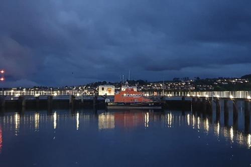 a boat docked at a dock in the water at night at The Fuzzy Duck in Broughty Ferry