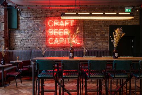 um bar com cadeiras e um sinal que lê artesanato beeraria em BrewDog DogHouse Edinburgh em Edimburgo