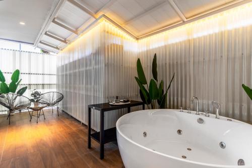 a large bathroom with a white tub and a table at Nest by Sangob in Bangkok