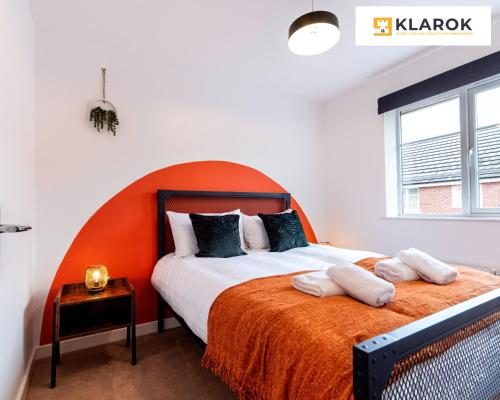 um quarto com uma cama grande e uma cabeceira laranja em LONG STAYS 30pct OFF - Beautiful 3 Bed & Parking By Klarok Short Lets & Serviced Accommodation em Peterborough