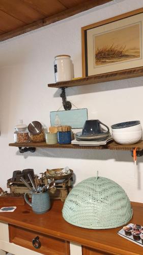 a shelf with plates and bowls on top of a table at Agréable chambre d'hôtes, au calme, dans la nature in Roches