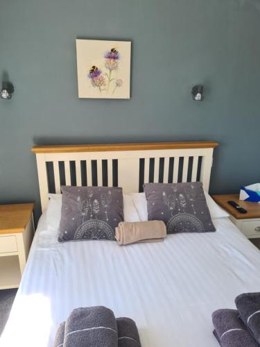 a bedroom with a white bed with two pillows at The Finch Hatton Arms in Sleaford
