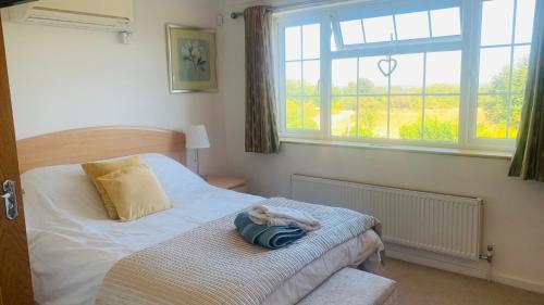 ein Schlafzimmer mit einem Bett und einem Handtuch darauf in der Unterkunft Lovekush Epsom Banstead Surrey. Views over London in Ewell