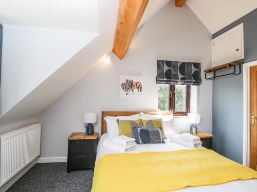 1 dormitorio con 1 cama con manta amarilla en Petals Patch, en Cheltenham
