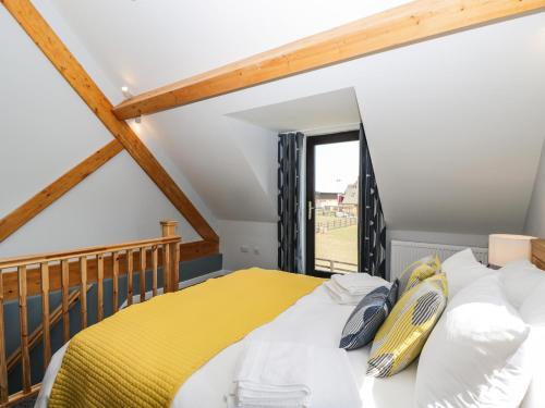 a bedroom with a yellow bed and a window at Petals Patch in Cheltenham