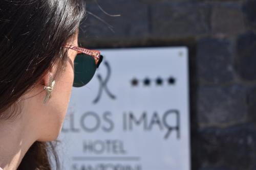 a woman wearing glasses with a pipe in her ear at Kallos Imar Boutique Hotel in Mesaria