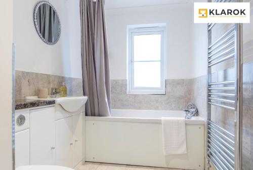 a bathroom with a tub and a toilet and a sink at LONG STAYS 30pct OFF - Spacious 4Bed - Sports Channels - Parking By Klarok Short Lets & Serviced Accommodation in Peterborough
