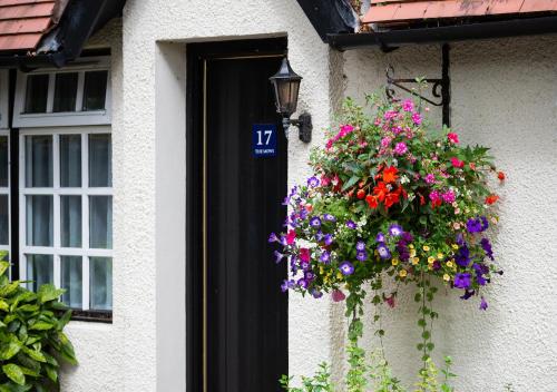 a hanging basket of flowers on the side of a house at Piersland House in Troon