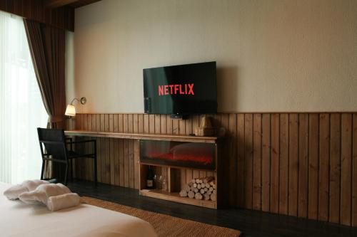 a hotel room with a television above a fireplace at Inlaya Ratchaburi in Ratchaburi