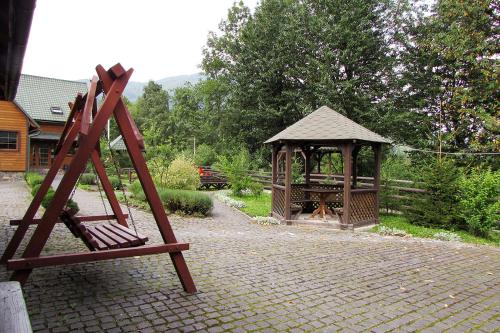 a wooden playground with a gazebo in a yard at Шале На бе́резі in Kvasy