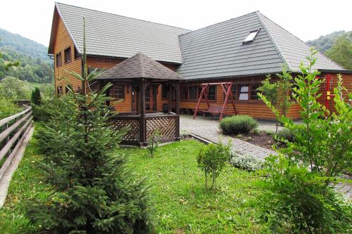 a wooden house with a gazebo in the yard at Шале На бе́резі in Kvasy