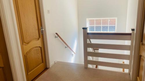 a room with a door and a window and a staircase at Lovekush Epsom Banstead Surrey. Views over London in Ewell