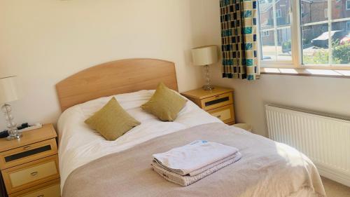 a bedroom with a bed with towels on it at Lovekush Epsom Banstead Surrey. Views over London in Ewell