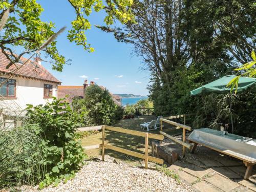 a garden with a bench and an umbrella at Heselwood in Lyme Regis