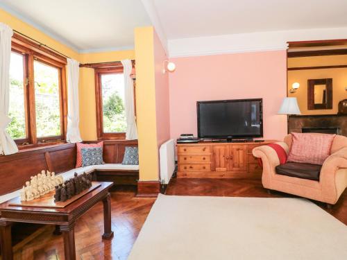 a living room with a tv and a couch at Heselwood in Lyme Regis
