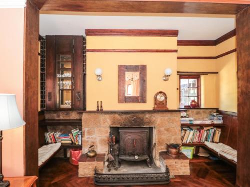 a living room with a stone fireplace and bookshelves at Heselwood in Lyme Regis