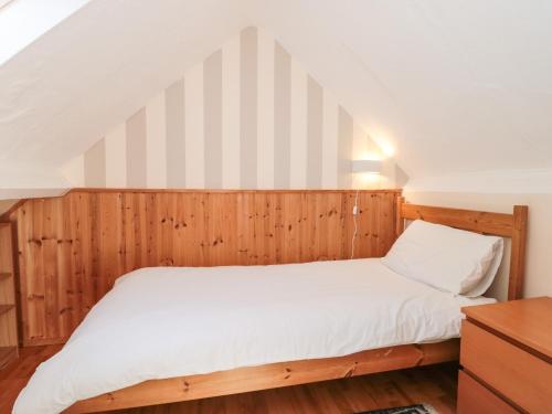 a bedroom with a bed with a wooden wall at Heselwood in Lyme Regis