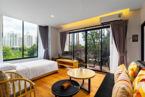 salon z łóżkiem i dużym oknem w obiekcie Nest by Sangob w mieście Bangkok