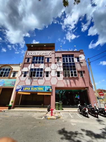 a hotel building with motorcycles parked in front of it at Hotel Bestari in Kuala Lipis