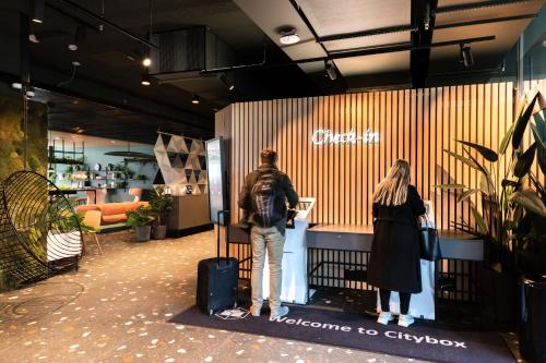 a man and woman standing in front of a store at Citybox Bergen Danmarksplass in Bergen