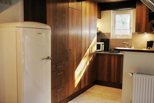 a kitchen with wooden cabinets and a white refrigerator at Hof von Felde in Soltau