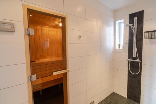uma casa de banho com um chuveiro e uma porta de madeira em Stylish and Spacious Family Home em Reiquiavique
