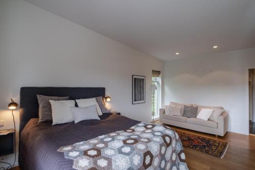 um quarto com uma cama grande e um sofá em Stylish and Spacious Family Home em Reiquiavique