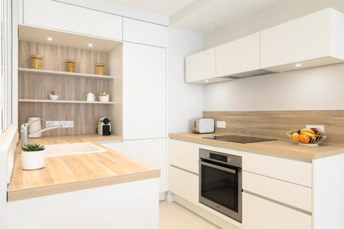 une cuisine avec des armoires blanches et un évier dans l'établissement Santa Monica   Annecy Rent Lodge, à Annecy