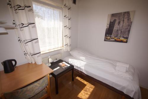 1 dormitorio con cama, escritorio y ventana en Egtved Hotel, en Egtved