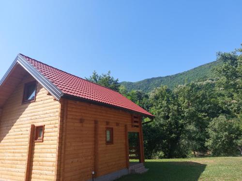 a small log cabin with a red roof at Apartmani Kajkut in Banja Luka