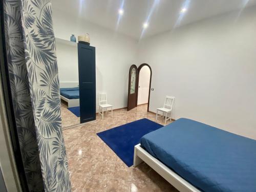 a bedroom with a blue bed and two chairs at Marechiaro Apartments in Palermo