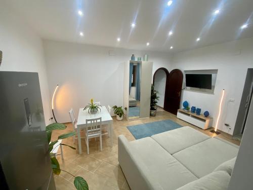 a living room with a white couch and a table at Marechiaro Apartments in Palermo