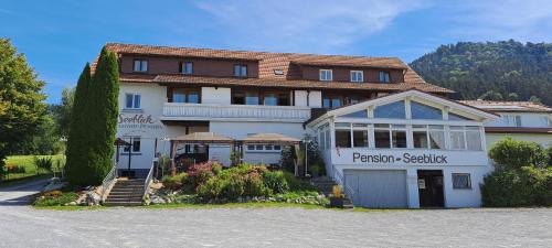 ein großes weißes Gebäude mit vielen Fenstern in der Unterkunft Pension Seeblick in Hörbranz