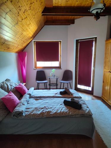 a bedroom with a large bed with two windows at Balaton Garden in Balatongyörök