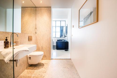 La salle de bains est pourvue de toilettes, d'un lavabo et d'une douche. dans l'établissement The Pier Ateliers by Daniel&Jacob's, à Copenhague