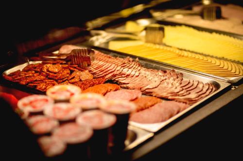 a buffet of meats and other foods on a table at Hotel Kapos in Kaposvár