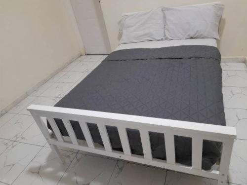 a bed in a room with a white frame at Bambino Guest House in Brikama