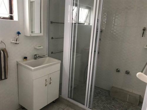 a bathroom with a shower and a sink at The Holiday Home on the Beach in Port Shepstone