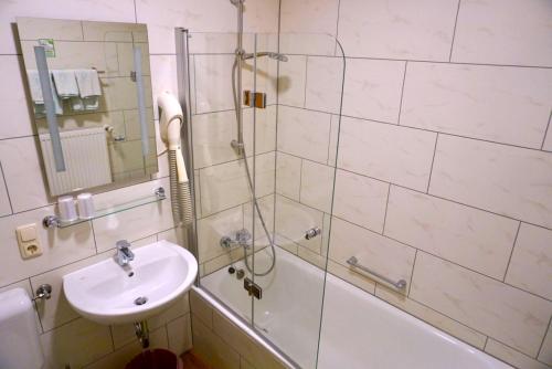 a bathroom with a shower and a sink and a tub at Gasthof zum Löwen in Gößweinstein