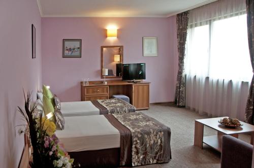 a hotel room with a bed and a television at Hotel Real in Plovdiv