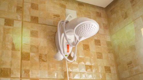 a shower head hanging on a wall in a bathroom at Local da Lagoa Chalés e Lofts in Imbituba